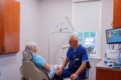 Dr. Rossetti speaking with a patient about dental services